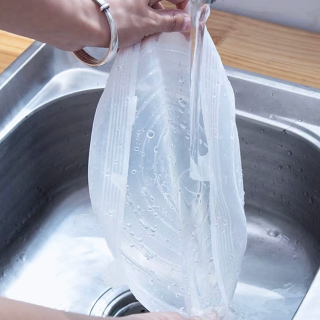 Person rinsing SiliCover under running water in a sink 